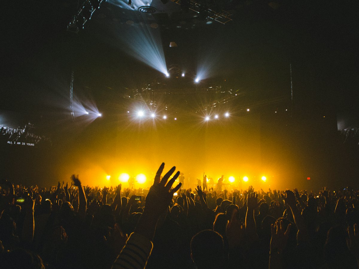 Crowd facing a lit stage at a concert