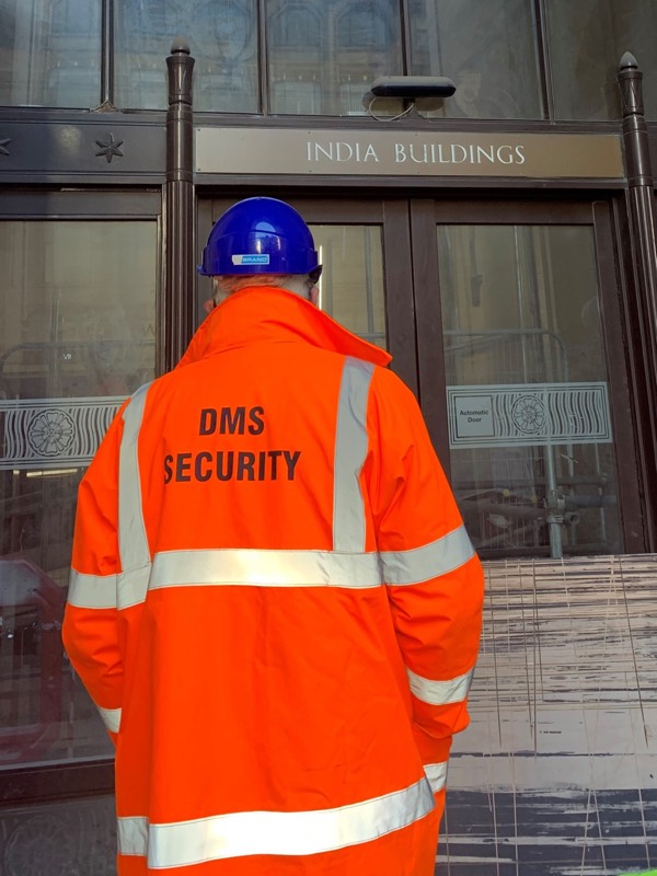 DMS security officer in a DMS Security hi-vis jacket outside India Buildings, Liverpool