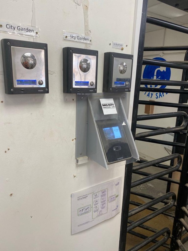 Intercom panels and a DMS facial recognition terminal installed beside a turnstile